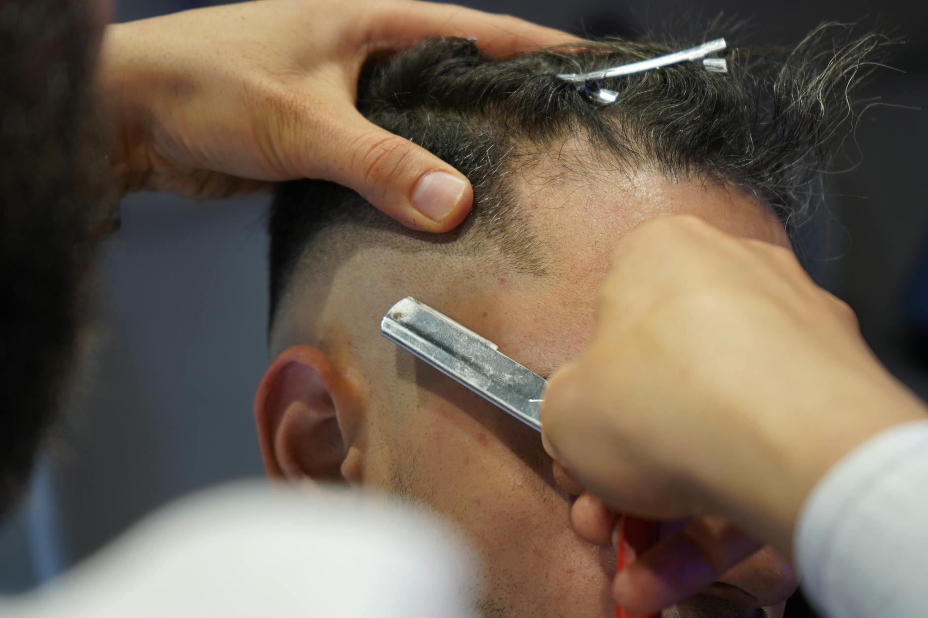 Barber performing a precise fade haircut with clippers